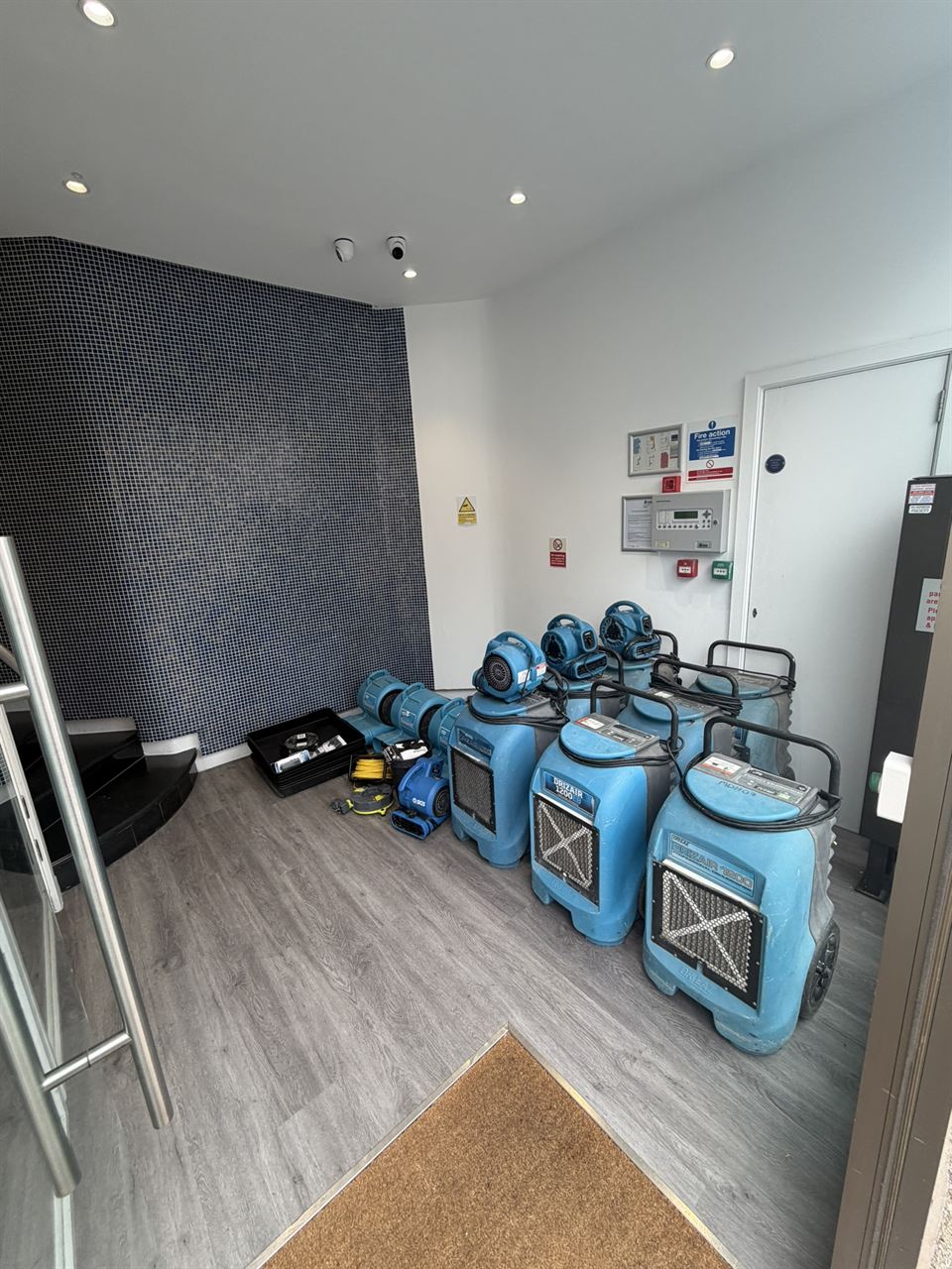 Several industrial dehumidifiers and air movers drying a commercial property